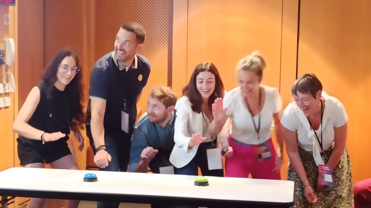 Participants en pleine animation gamifiée, buzzers sur la table