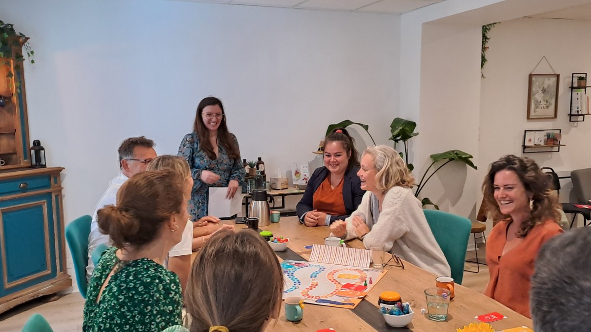 Participants riant autour d'un jeu de plateau pendant une sensibilisation MiiS